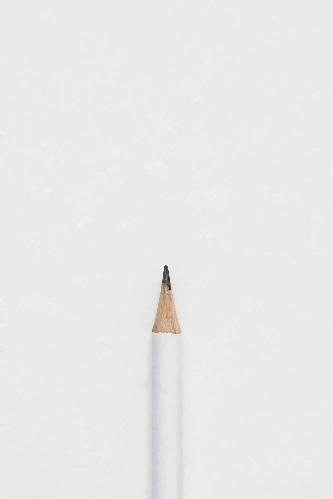 A sharpened white pencil on a white background